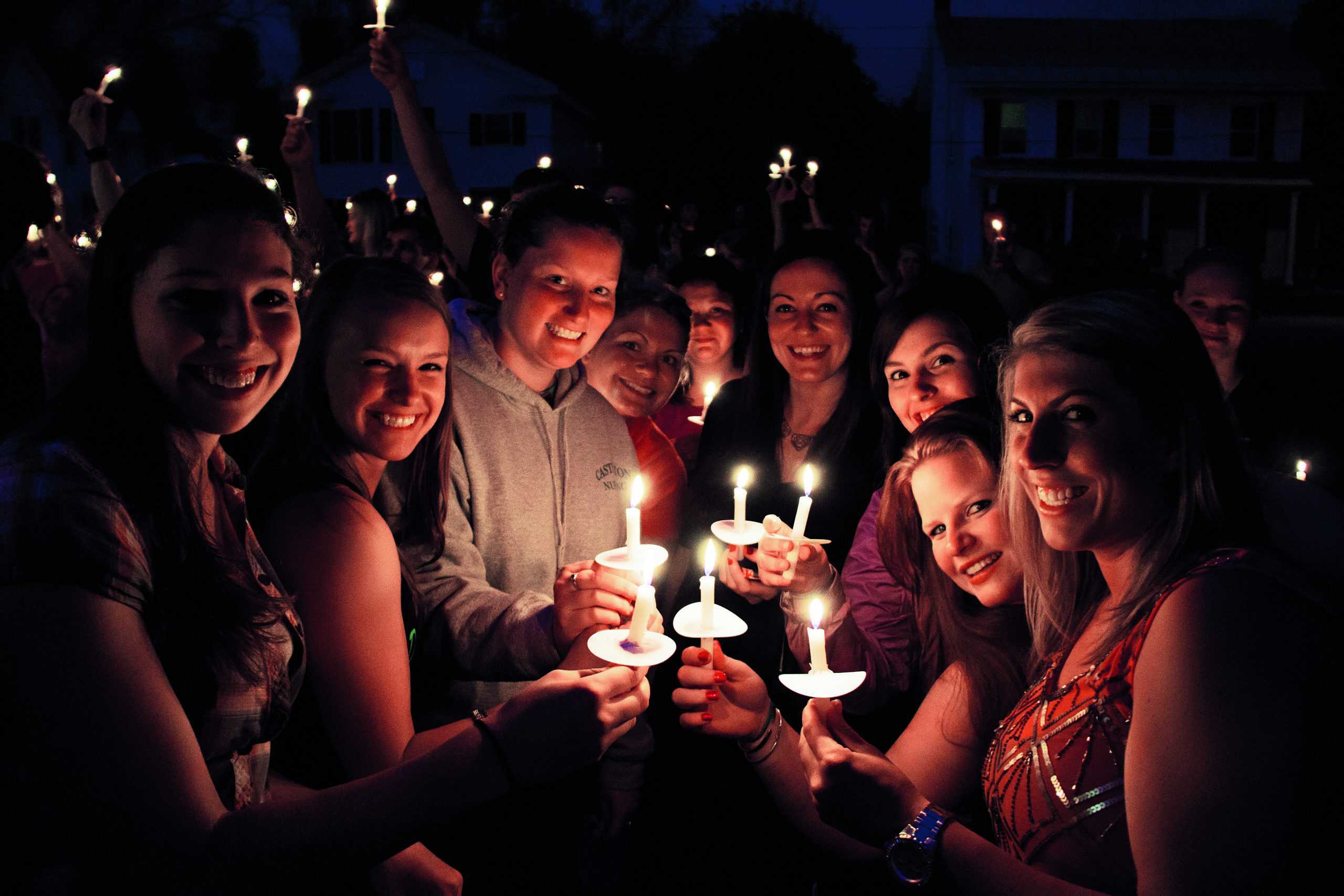 Group of female students hold candles during evening vigil