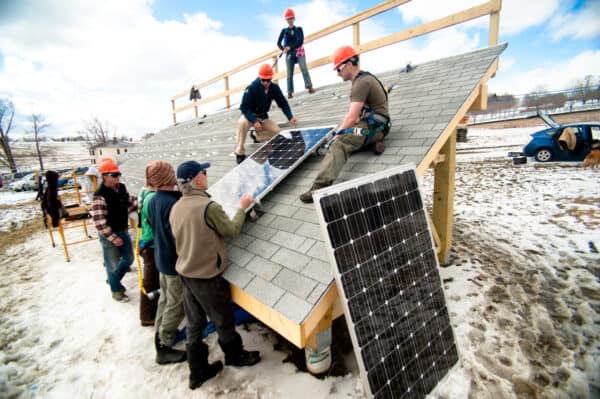 Group of students learn how to install solar panels on the Randolph Center campus