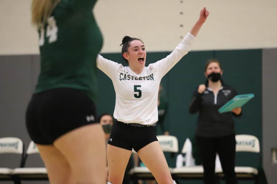 Women volleyball player cheers from the court on the Castleton campus