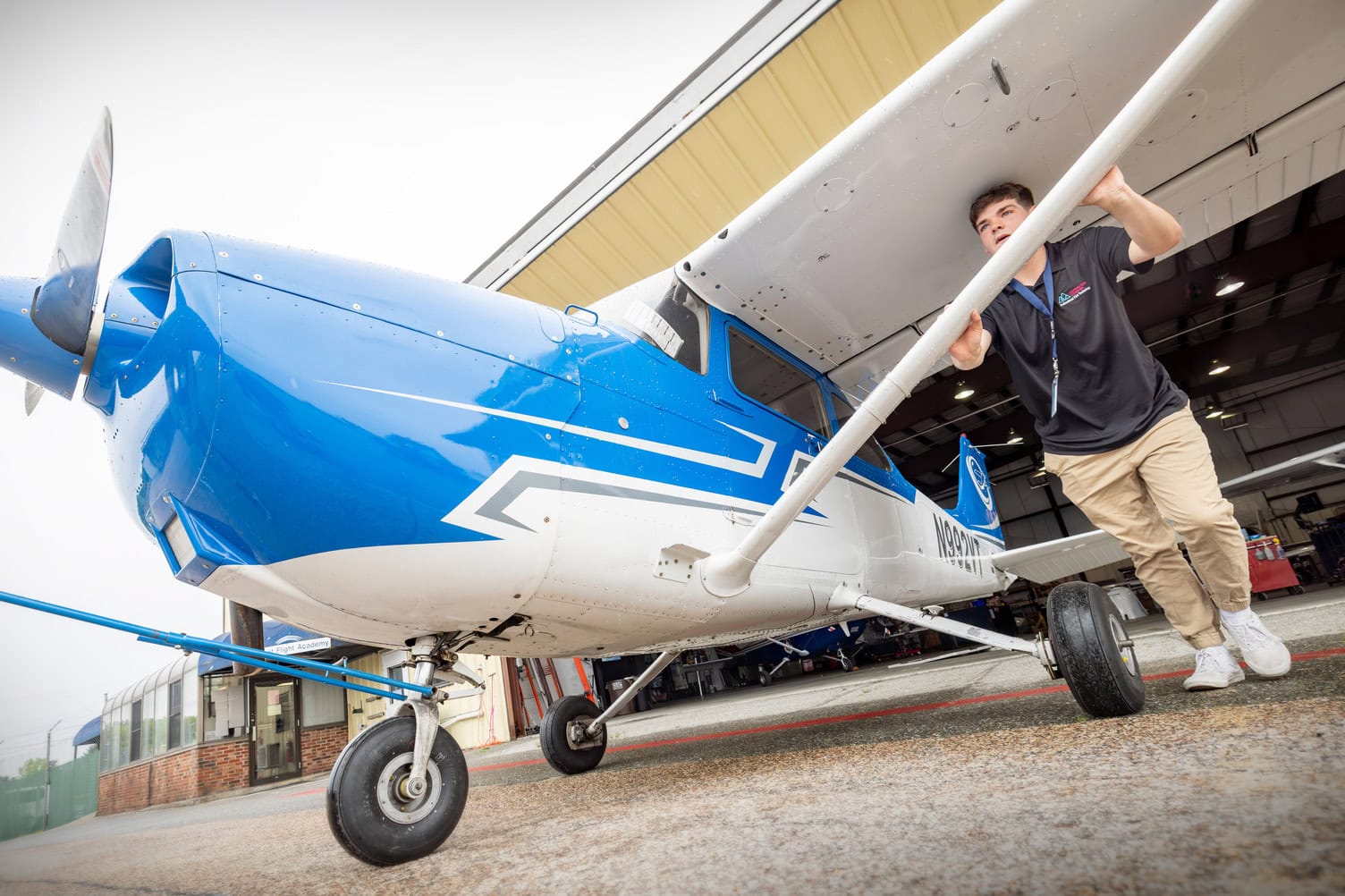 A young man pushing a small airplane
