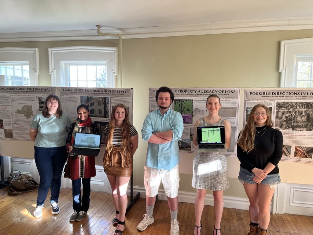 A line of Vermont State University students stand presenting projects.
