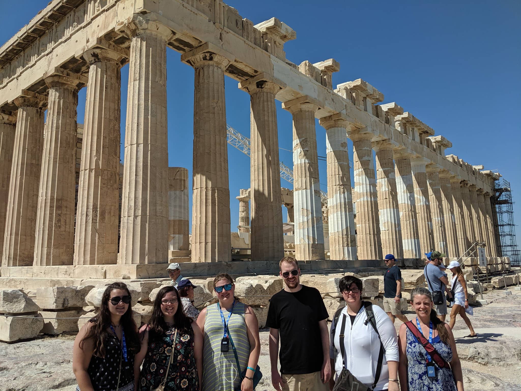 a group of people posing in front of the Parthenon.
