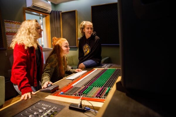 The girls in an audio recording studio on the Vermont State University Lyndon campus.
