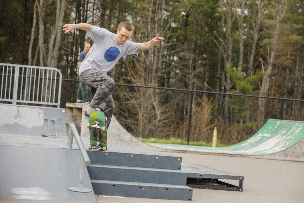 A young man jumping a skateboard in the Vermont State University Lyndon campus.
