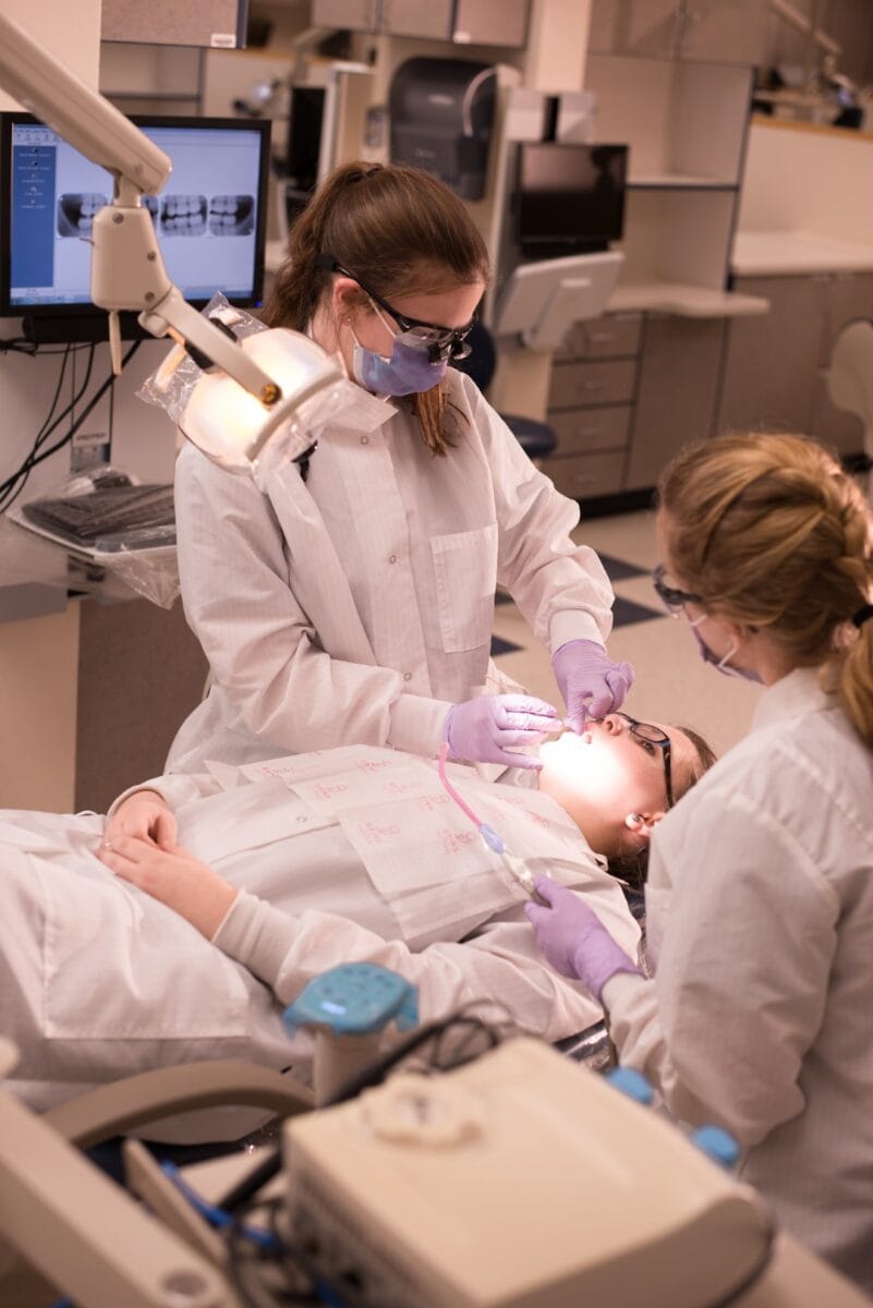 A dental hygiene student at Vermont State University examines the mouth of a patient. 