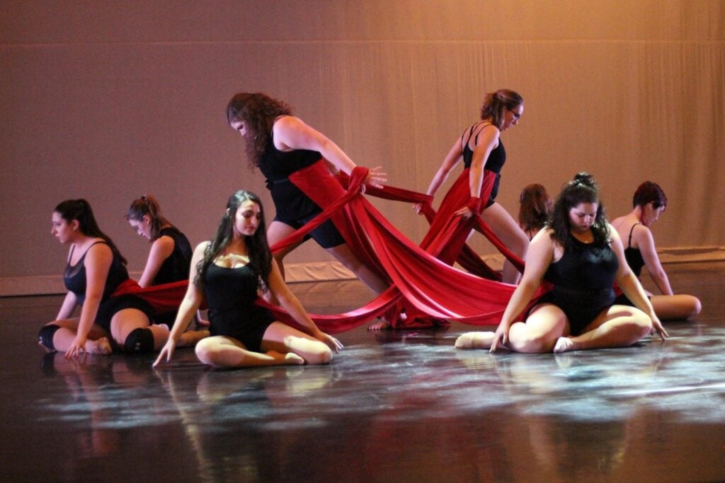 A group of students on a stage dancing at Vermont State University Johnson.