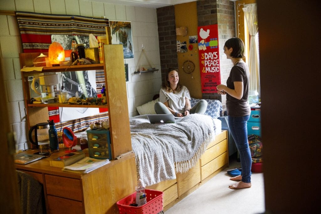 Two your women chat in a residence hall room on the Vermont State University Johnson campus.