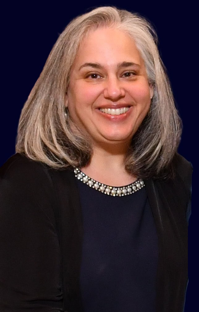 Heather Blair, a woman in professional clothing with shoulder-length grey hair, smiling at the camera.