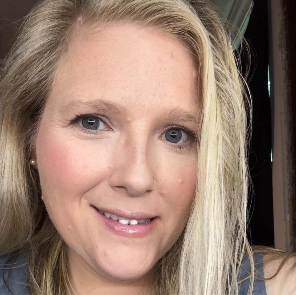 A woman with long blonde hair and blue eyes.