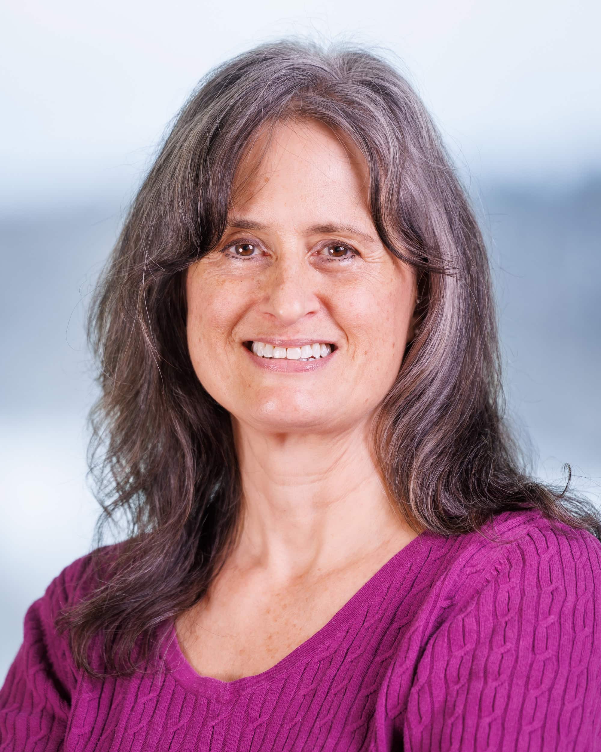 Stephanie Dorosko, a woman wearing a pink colored shirt smiling at the camera