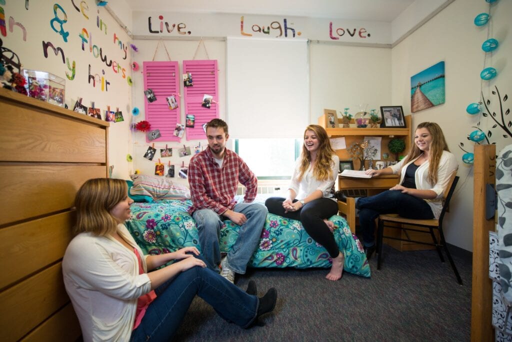 Three friends gather in a Vermont State University Randolph dorm room and chat.