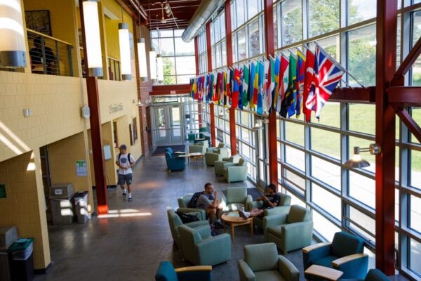 A study space on the Vermont State University Castleton campus with large windows and the flags of many countries on display.