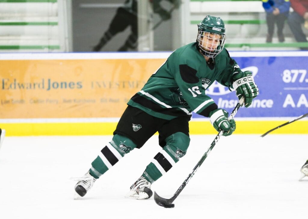 A male hockey player skates with intense focus in the Spartan Arena.