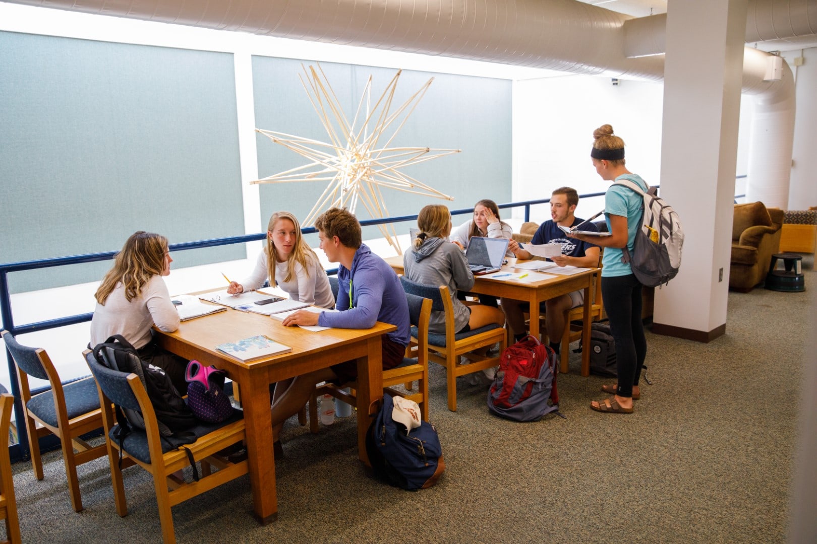 Groups of students in a brightly lit study space in the Castleton library.
