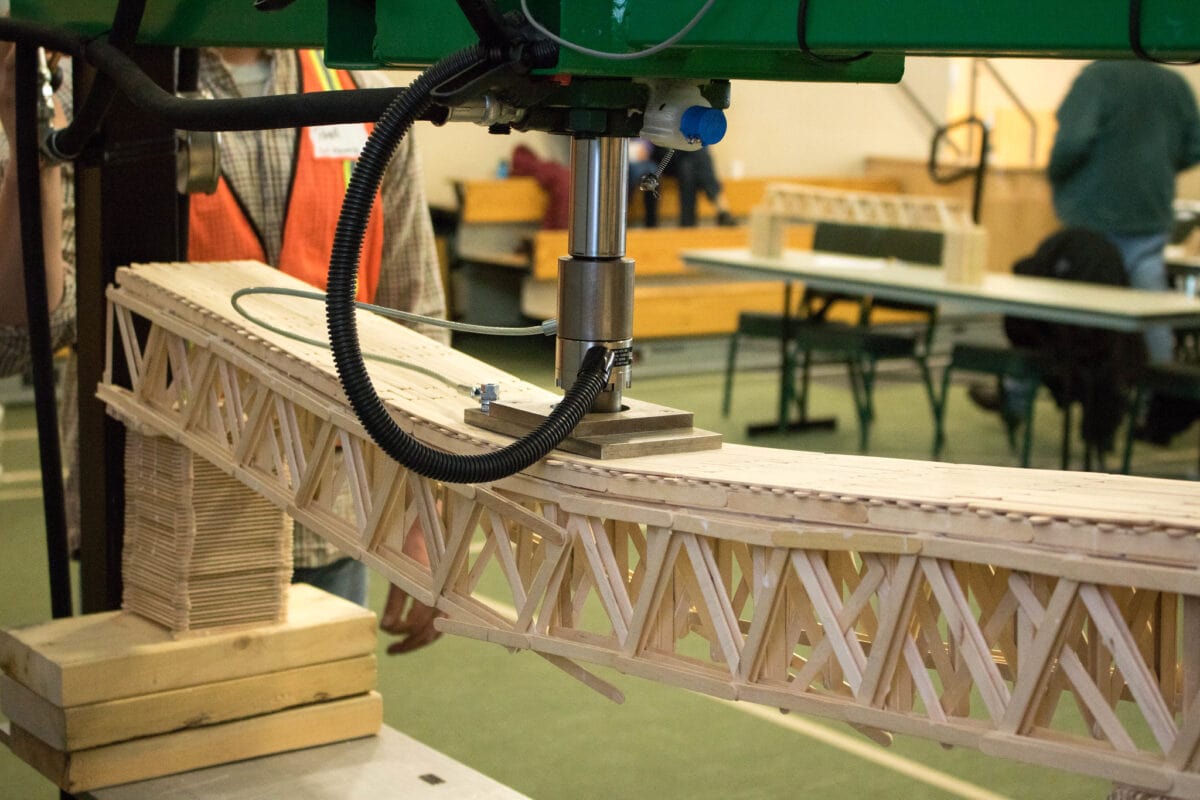 A popsicle stick bridge buckles under pressure of a machine at the Vermont State University bridge building competition.