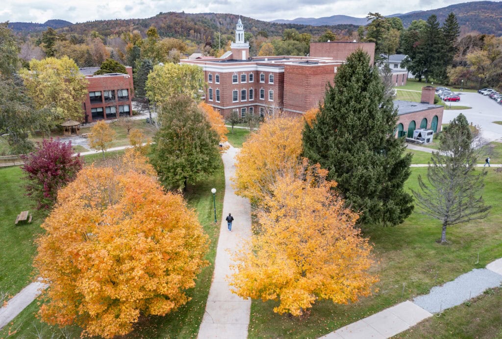 Fall photography at Vermont State University Castleton Campus. brick buildings in the background and three path leading towards them.