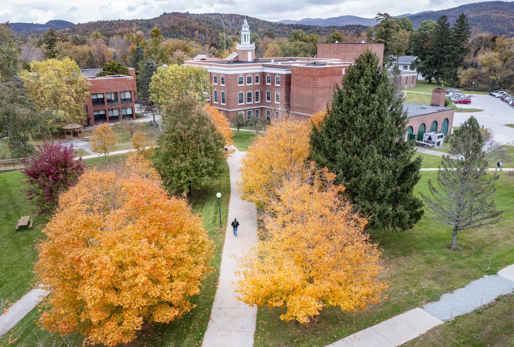 Fall photography at Vermont State University Castleton Campus. brick buildings in the background and three path leading towards them.