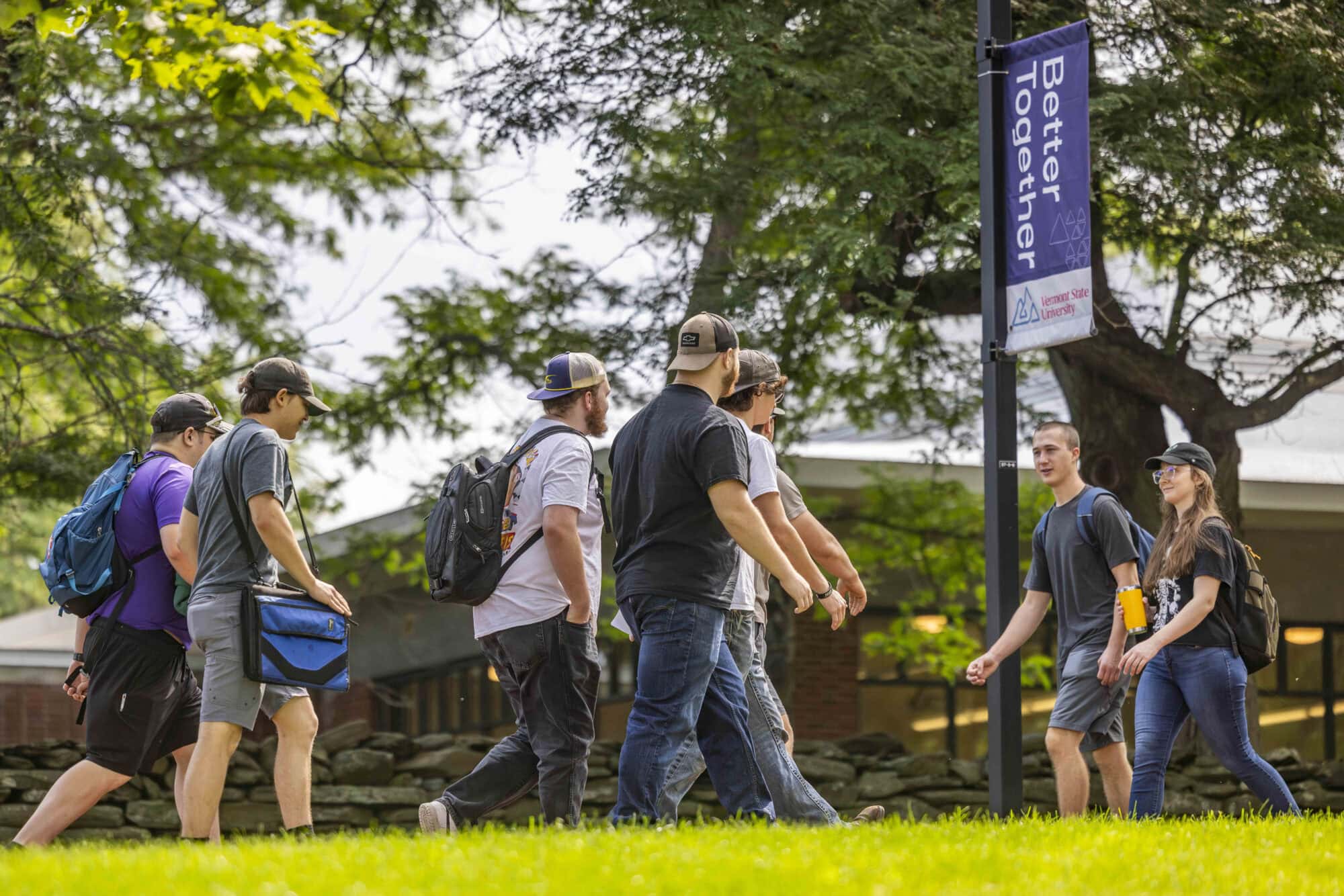 A line of students walking on a path at Vermont State University.