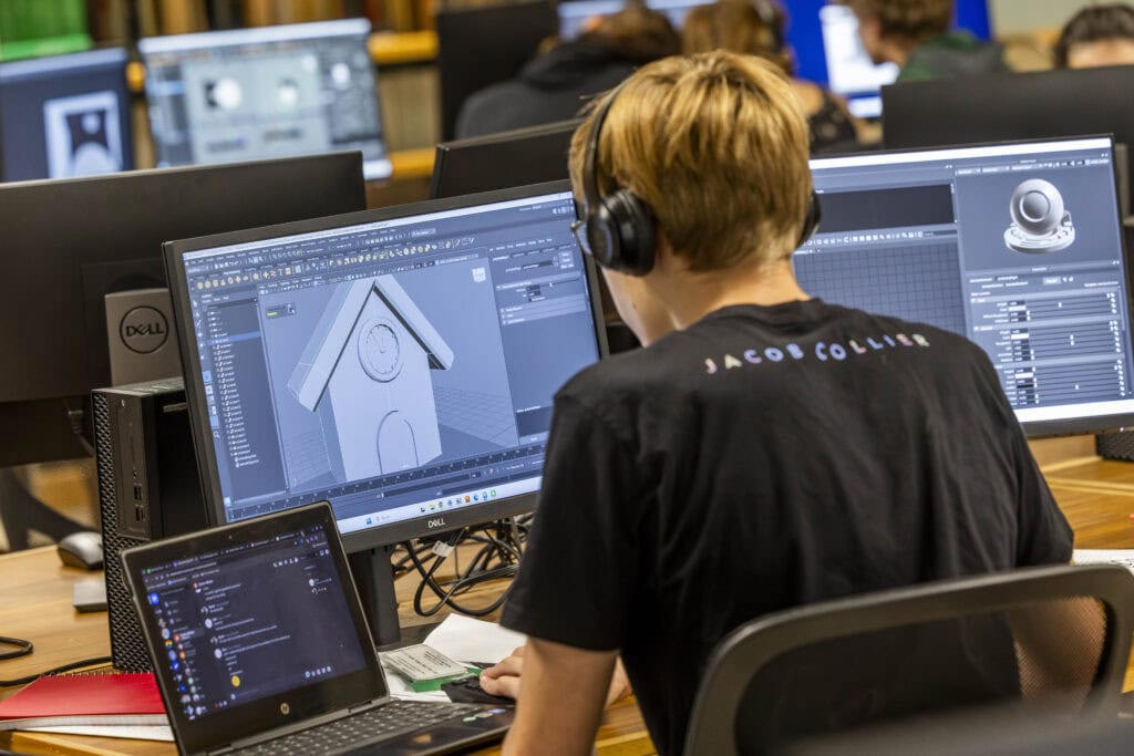 A student using 3d modeling software at a computer