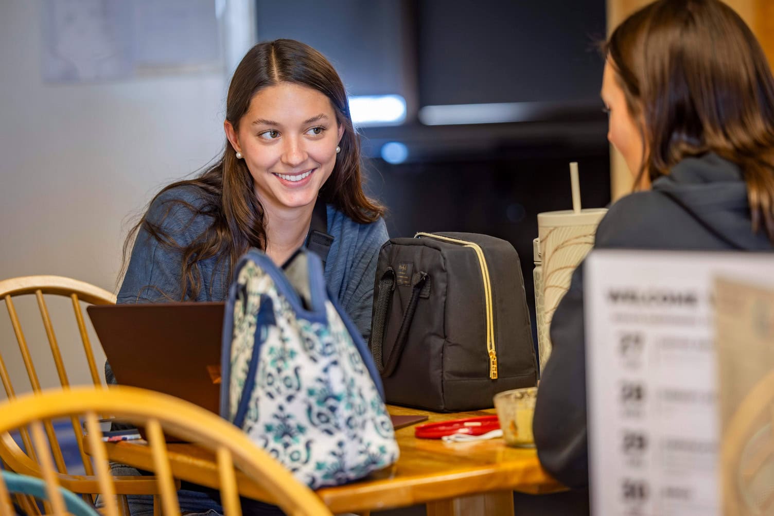 Two students sitting and eating lunch while working at computers