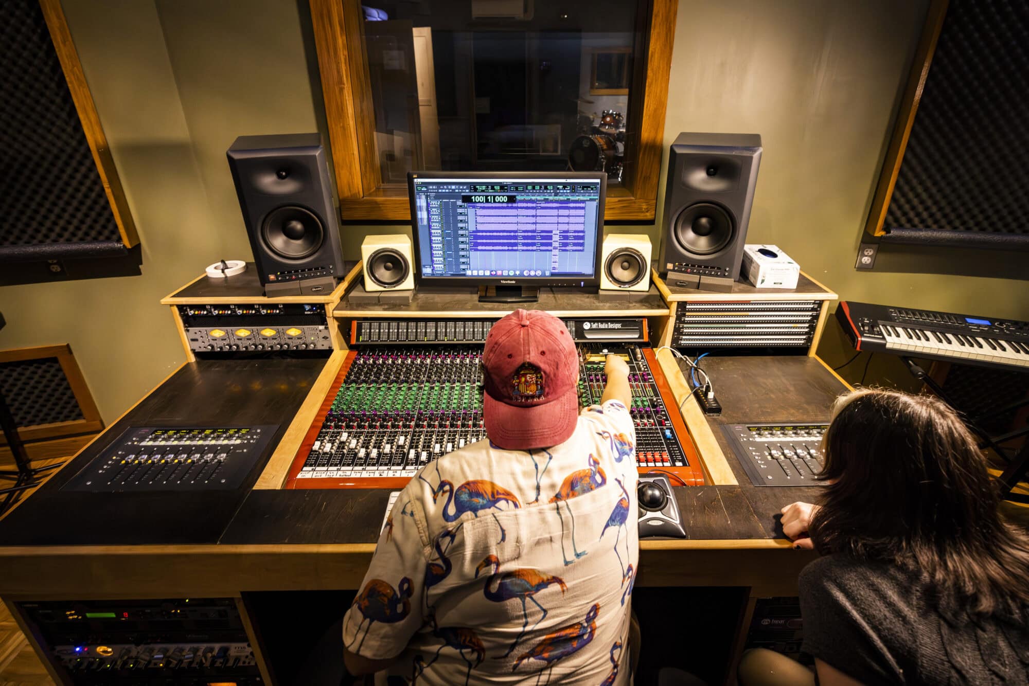 Students sit at an audio mixing board inside a recording studio at VTSU Lyndon