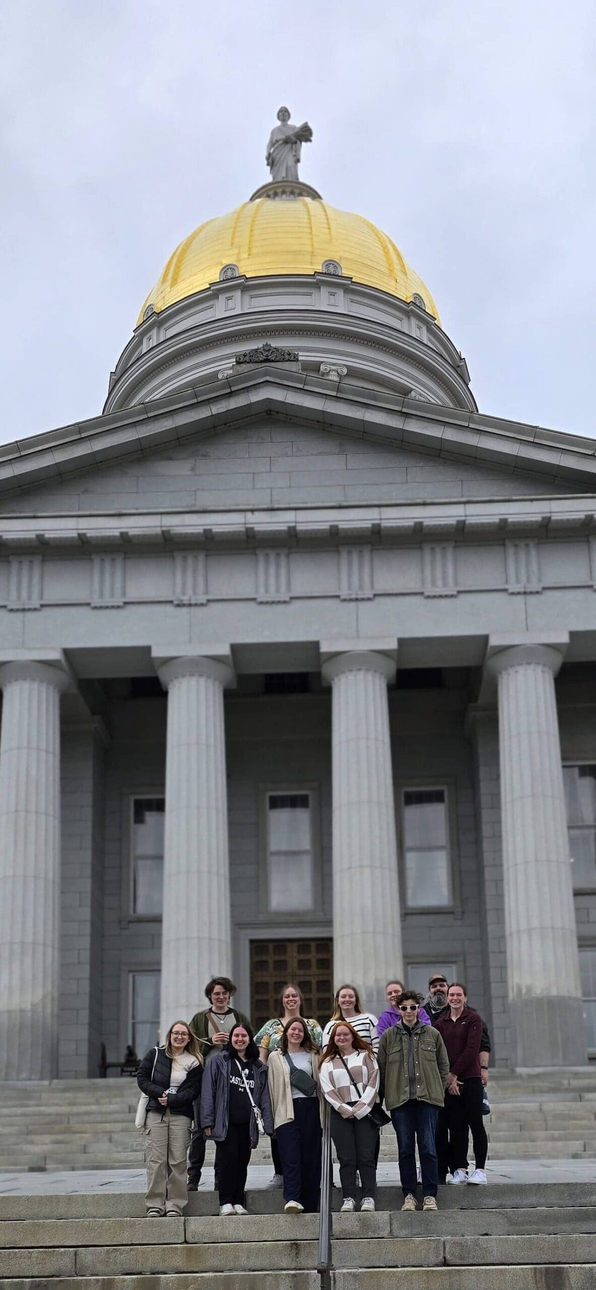 Students smiling on state house steps