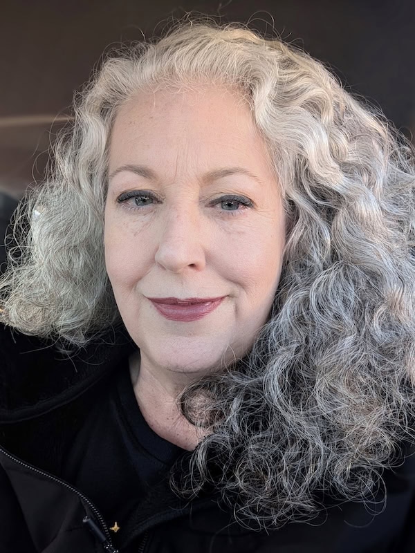 A woman with gray hair and a black jacket.