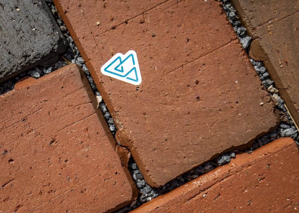 A small sticker of the VTSU mountain logo on red bricks.
