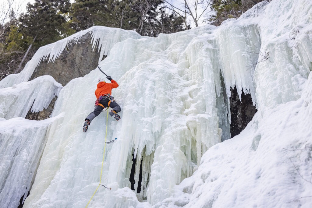 A man ice climbing a cliff