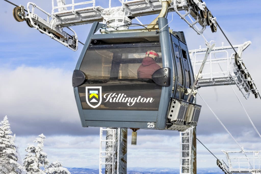A blue gondola at Killington Resort with snowy fields in the background