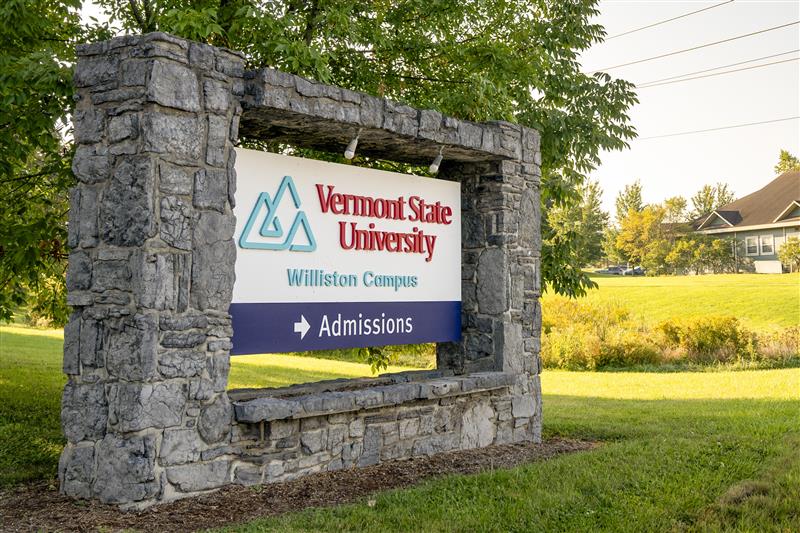 The entrance sign to VTSU Williston campus, mounted on a stone frame.