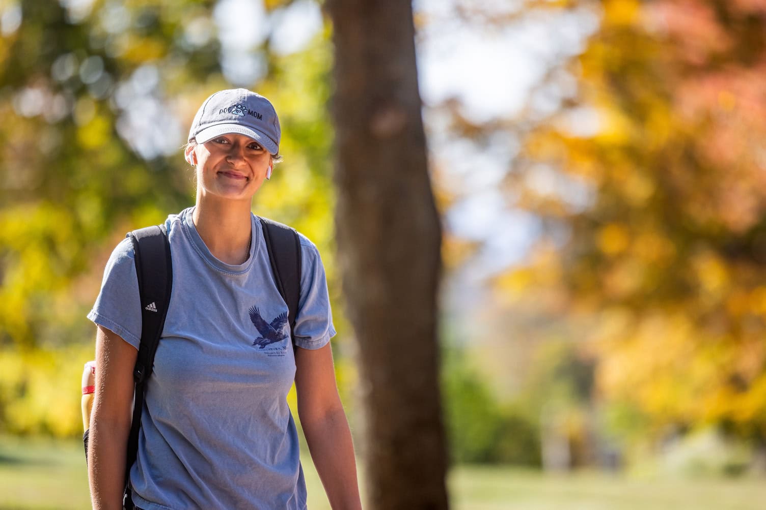A student walks on campus during peak fall foliage at Vermont State University Randolph