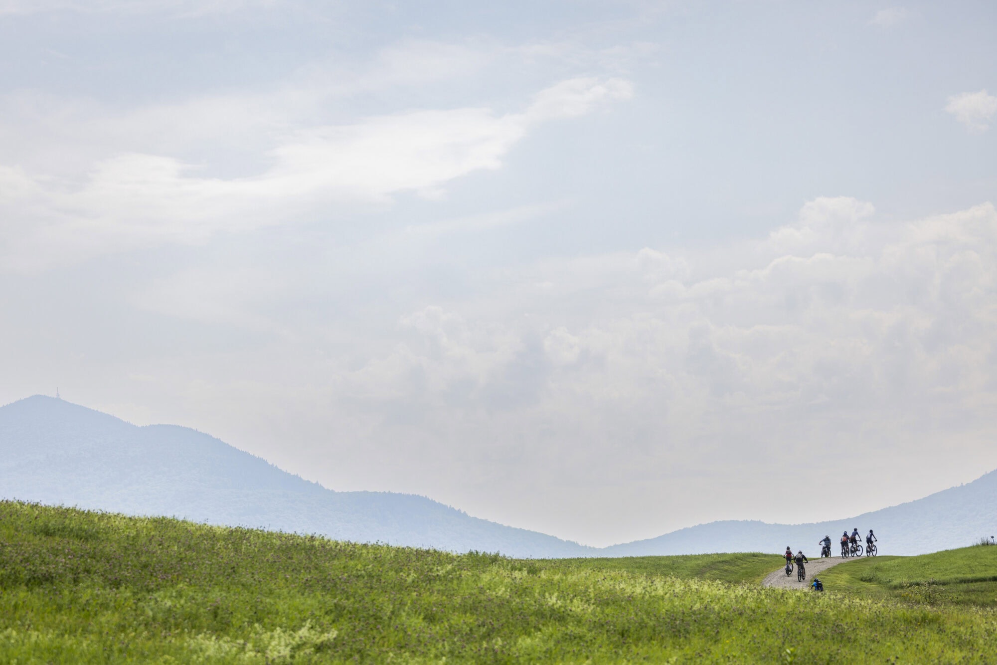 A scenic view of mountains from a large grassy area in Vermont