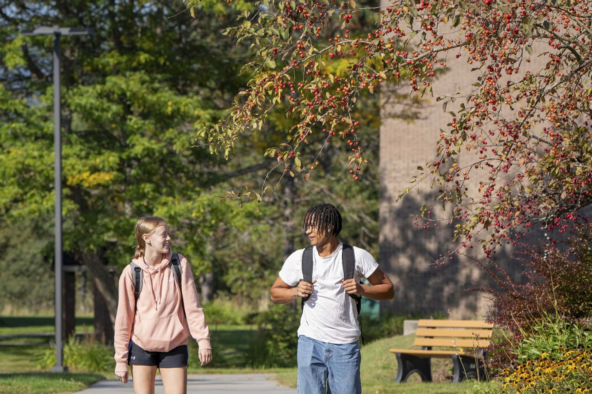 Two students walk together at Vermont State University Johnson on a fall day