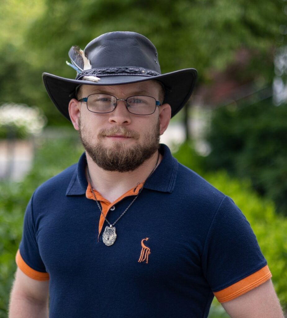 Gavin Bradley standing outside in a park and smiling at the camera