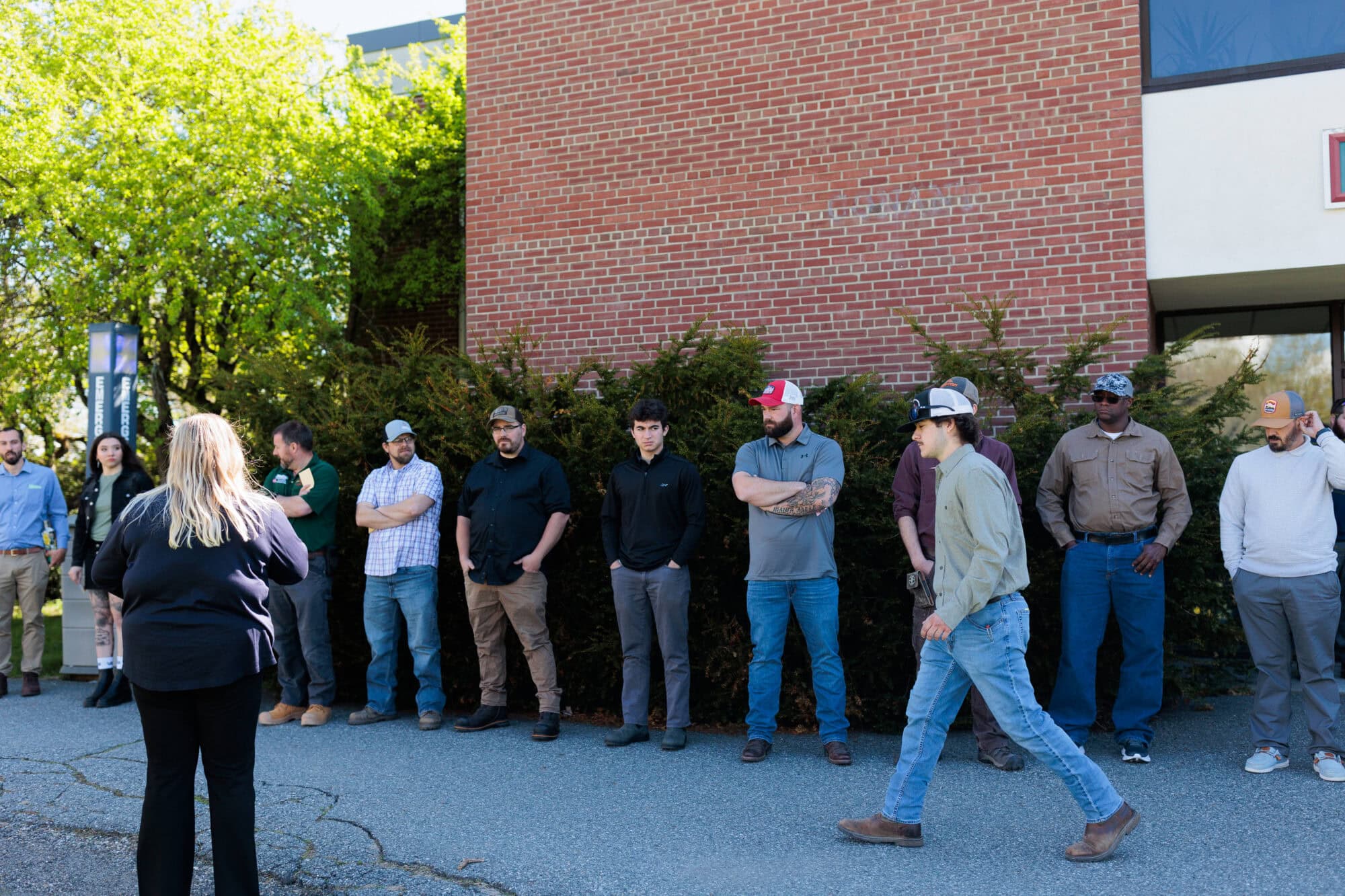 A group of men standing in a line outside of a brick building