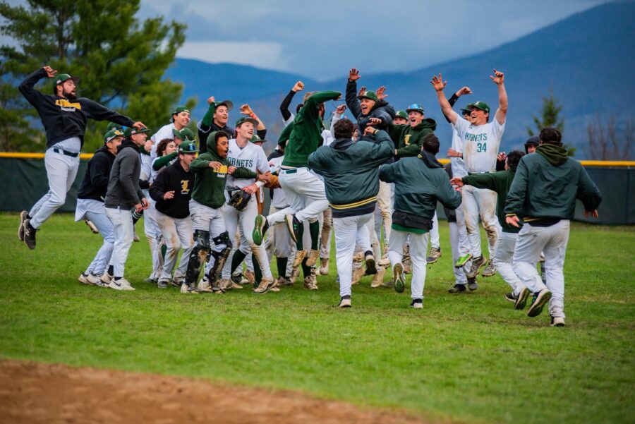 A group of VTSU Lyndon  baseball players cheering and celebrating on the field
