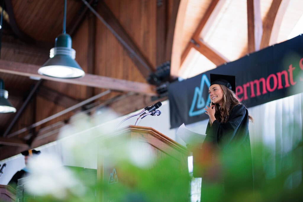A young woman standing at a lectern giving a speech
