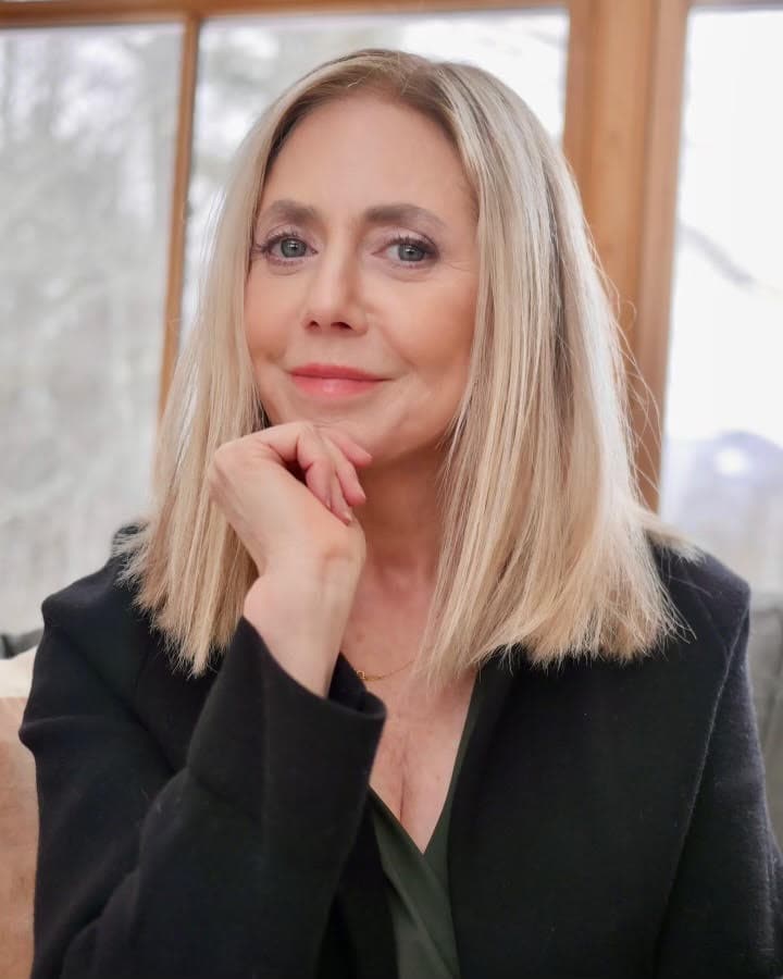 Elizabeth Powell wearing a black blazer and smiling at the camera