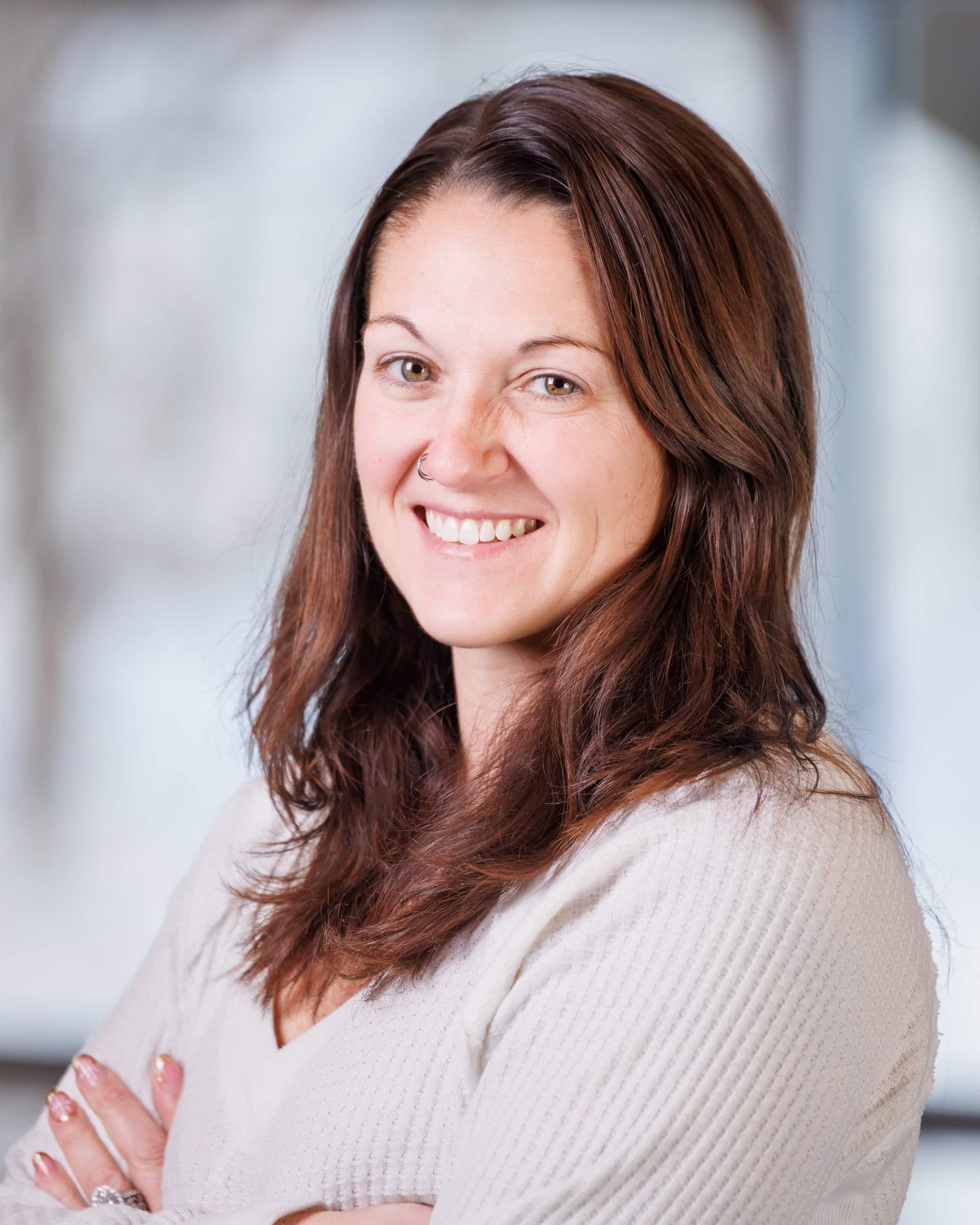 Kim Maniery standing in a well lit room and smiling at the camera