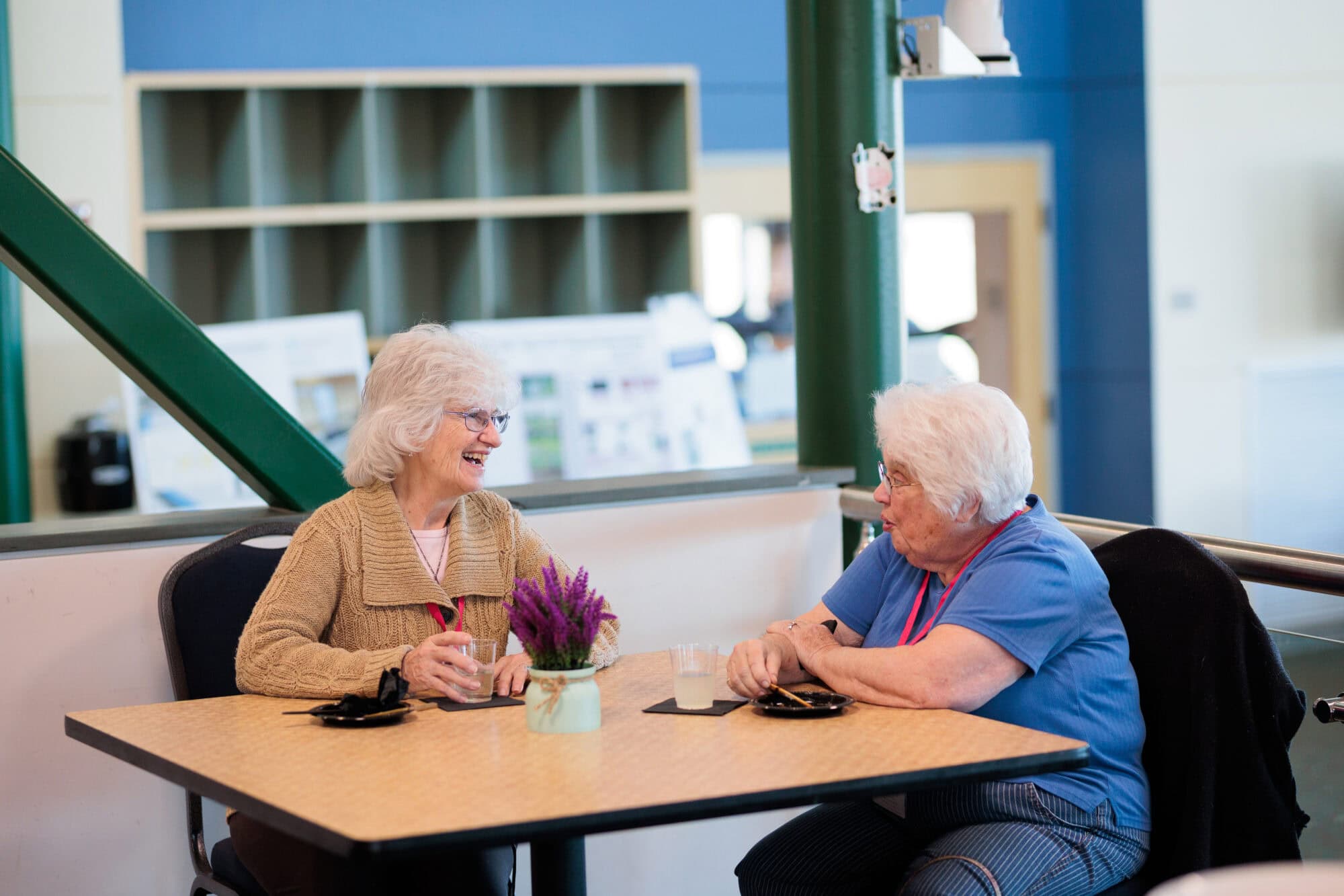 Two women sitting at a table and conversing with each other